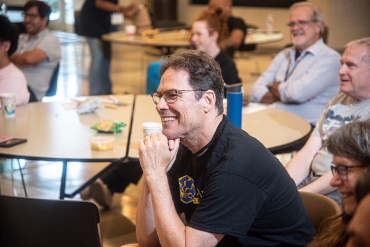 A participant smiling over lunch with other musicians